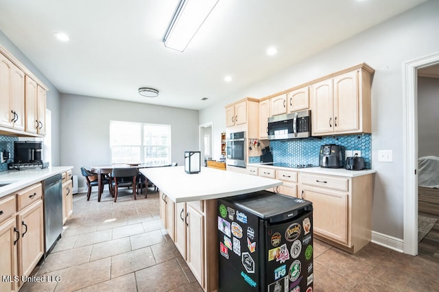 10053 Kingston Rd, Bay Saint Louis, MS 39520 - kitchen featuring appliances with stainless steel finishes, light brown cabinetry, decorative backsplash, light countertops, and recessed lighting