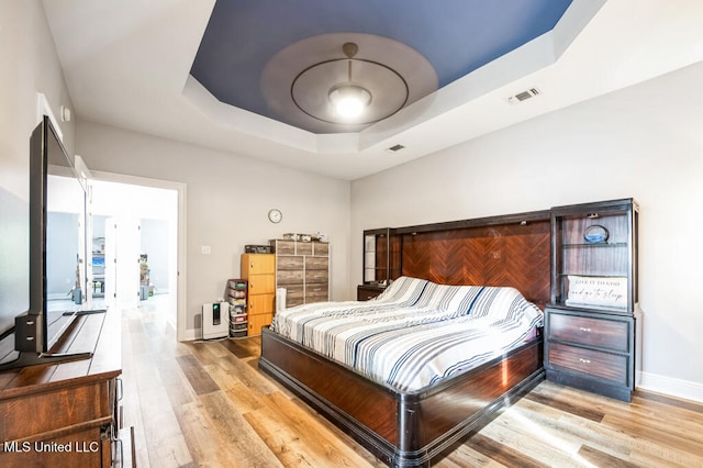 10053 Kingston Rd, Bay Saint Louis, MS 39520 - bedroom featuring a raised ceiling, wood finished floors, and baseboards