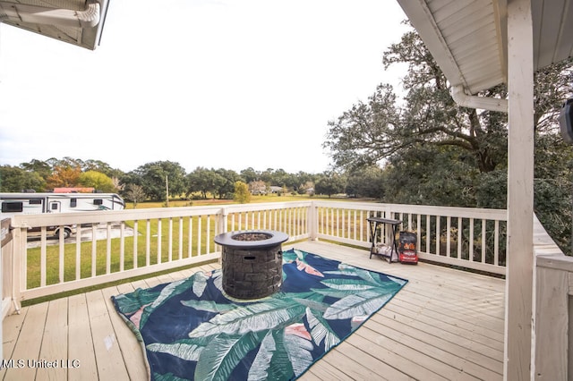 10053 Kingston Rd, Bay Saint Louis, MS 39520 - wooden deck featuring an outdoor fire pit, a lawn, and view of wooded area