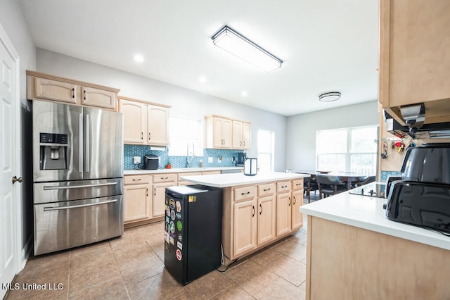 10053 Kingston Rd, Bay Saint Louis, MS 39520 - kitchen with stainless steel fridge with ice dispenser, light brown cabinets, light countertops, a kitchen island, and backsplash