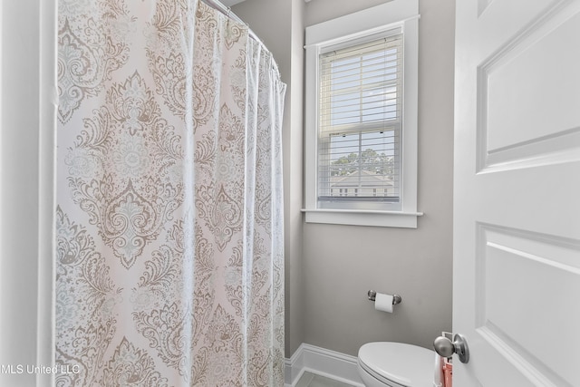 full bath with a shower with curtain, baseboards, and toilet