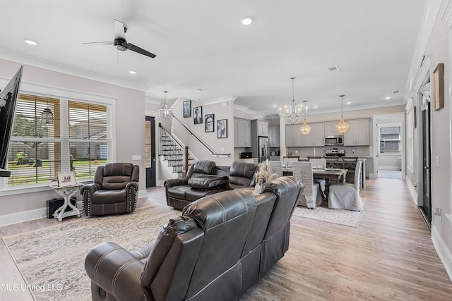 living area with crown molding, recessed lighting, stairway, light wood-type flooring, and ceiling fan with notable chandelier