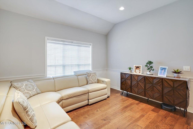living room with recessed lighting, lofted ceiling, and light wood-type flooring