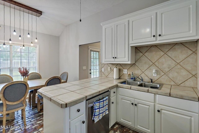 kitchen featuring backsplash, a peninsula, a wealth of natural light, and a sink