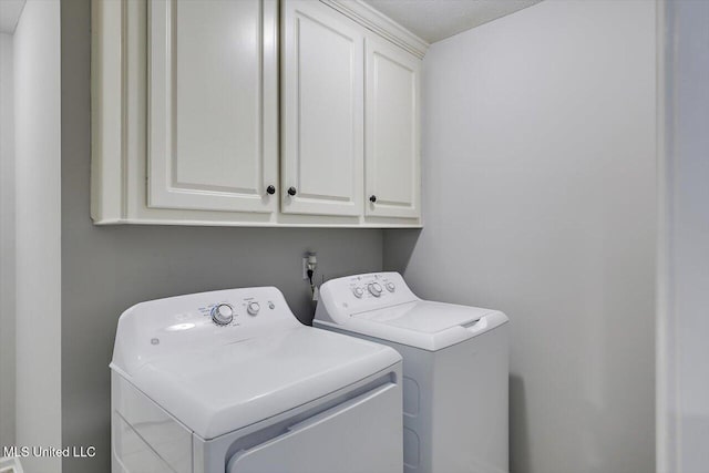 washroom with cabinet space and washing machine and clothes dryer