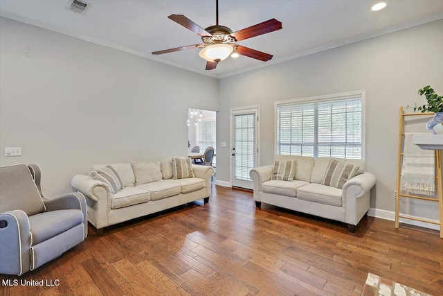 living area featuring visible vents, ornamental molding, baseboards, hardwood / wood-style flooring, and a ceiling fan
