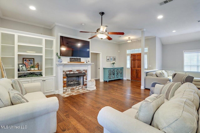 living room with crown molding, ceiling fan, visible vents, and wood finished floors