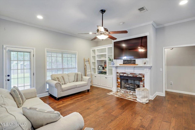 living area featuring ceiling fan, dark wood-style flooring, a stone fireplace, and visible vents