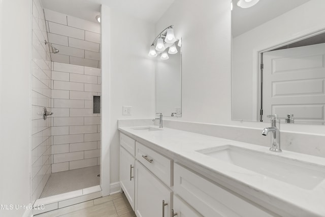 bathroom featuring vanity, tile patterned floors, and a tile shower