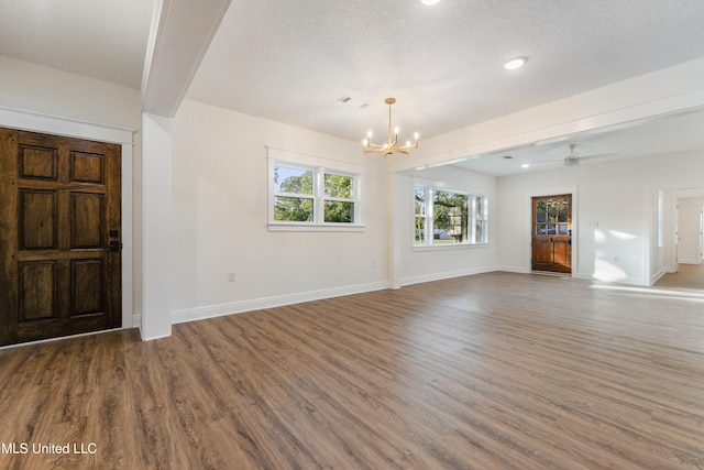 unfurnished living room featuring hardwood / wood-style floors, ceiling fan with notable chandelier, and a textured ceiling