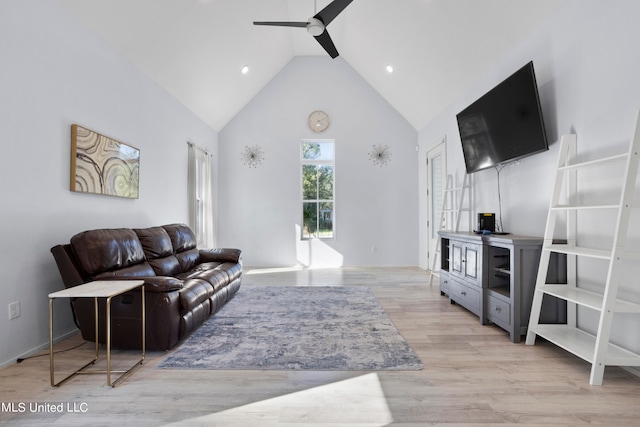 living room with light hardwood / wood-style flooring, high vaulted ceiling, and ceiling fan