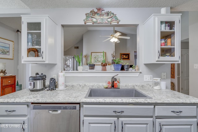 kitchen with light countertops, glass insert cabinets, white cabinetry, a sink, and dishwasher