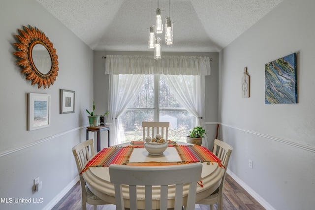 dining space with dark wood-style floors, a textured ceiling, and baseboards