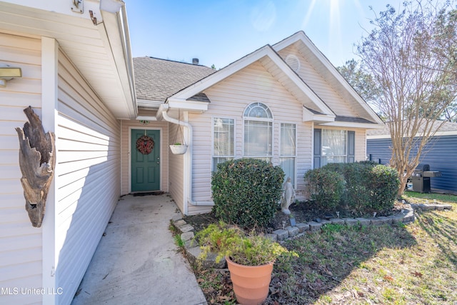 property entrance with a shingled roof