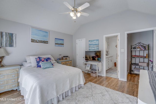 bedroom featuring lofted ceiling, light wood-type flooring, ceiling fan, and ensuite bathroom