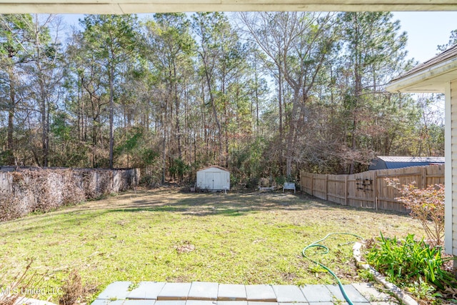 view of yard featuring a shed, an outdoor structure, and a fenced backyard