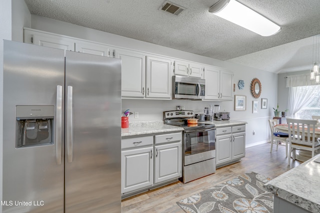 kitchen with white cabinets, visible vents, appliances with stainless steel finishes, and light countertops