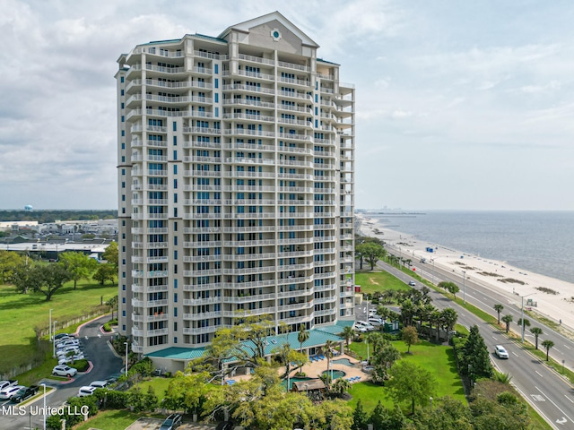 view of building exterior with a water view and a view of the beach