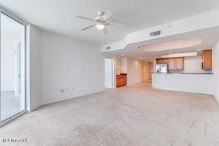 unfurnished living room with visible vents, carpet flooring, and ceiling fan