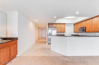 kitchen featuring brown cabinets, dark countertops, stainless steel appliances, and recessed lighting