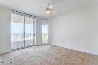 carpeted spare room featuring ceiling fan