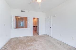 unfurnished room with visible vents and a ceiling fan