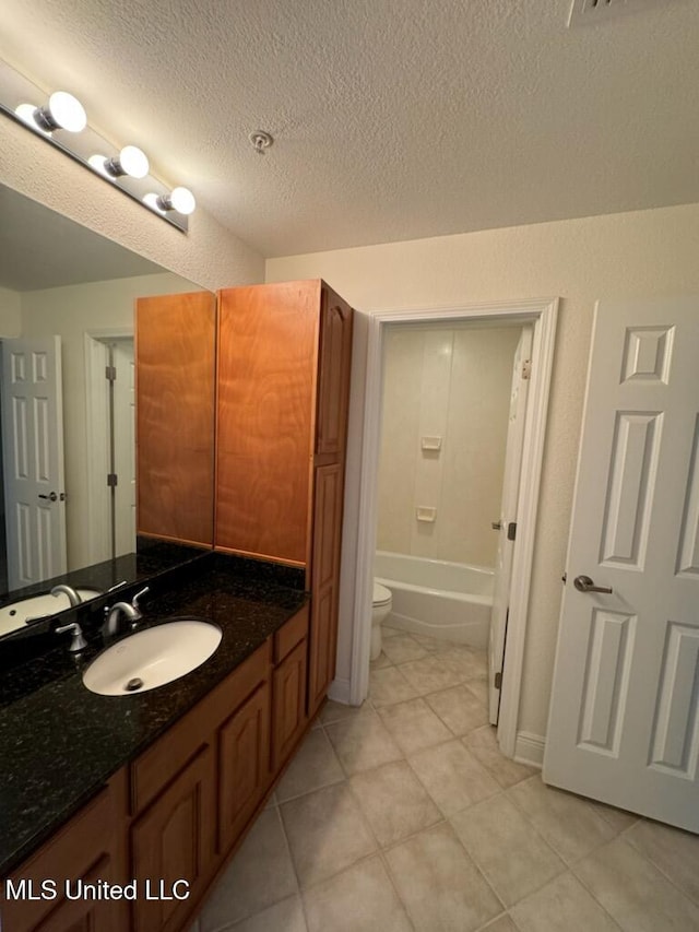 bathroom with vanity, a textured ceiling, toilet, and tile patterned floors