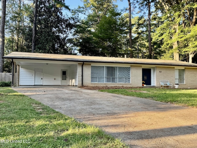 ranch-style home with an attached carport, a front lawn, concrete driveway, and brick siding