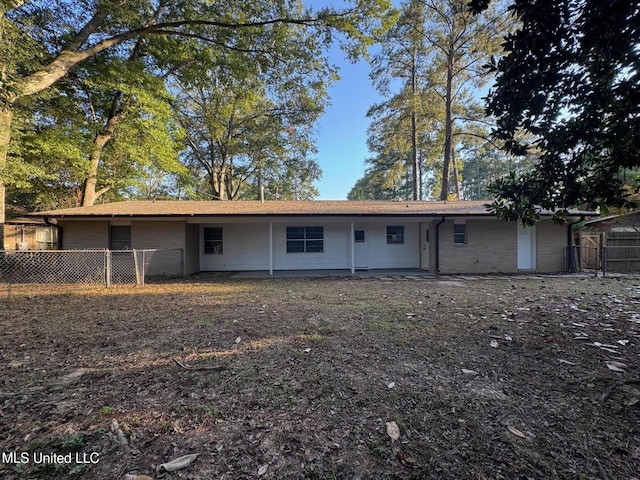 rear view of house featuring fence