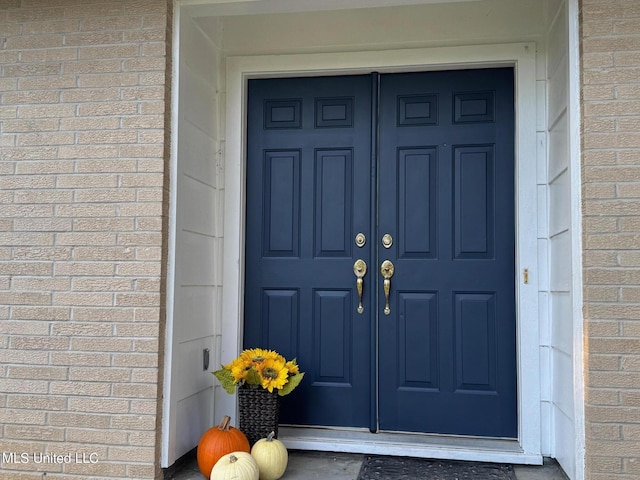 doorway to property with brick siding