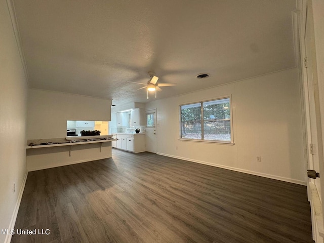 unfurnished living room featuring baseboards, dark wood-style floors, visible vents, and ceiling fan