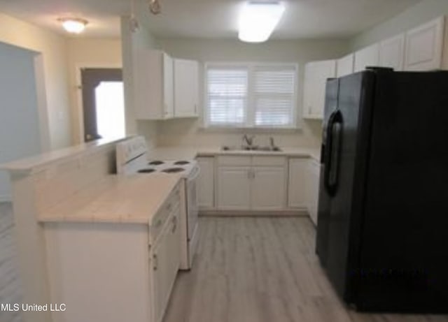 kitchen featuring white electric range oven, black fridge with ice dispenser, kitchen peninsula, and white cabinets