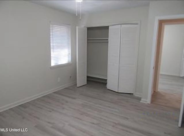 unfurnished bedroom featuring light hardwood / wood-style floors and a closet