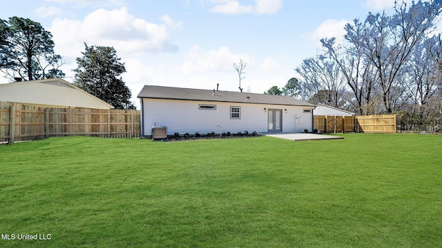 rear view of property with a yard, a patio area, a fenced backyard, and central air condition unit