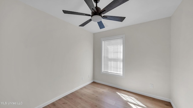 spare room with light wood-type flooring, ceiling fan, and baseboards