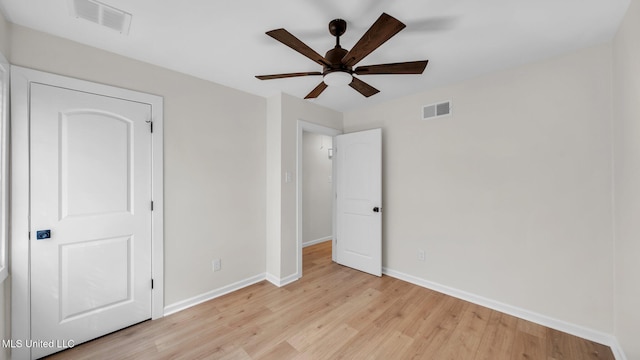 unfurnished bedroom with light wood-style flooring, a ceiling fan, visible vents, and baseboards