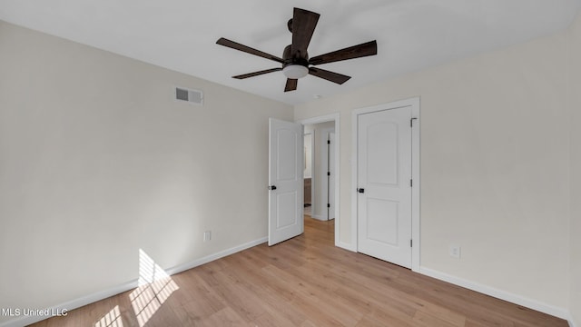 unfurnished bedroom featuring light wood finished floors, a ceiling fan, visible vents, and baseboards