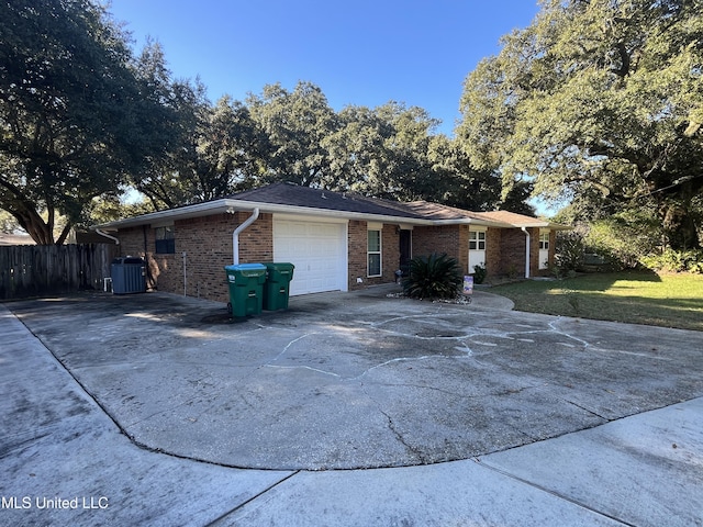 single story home featuring central AC unit and a garage