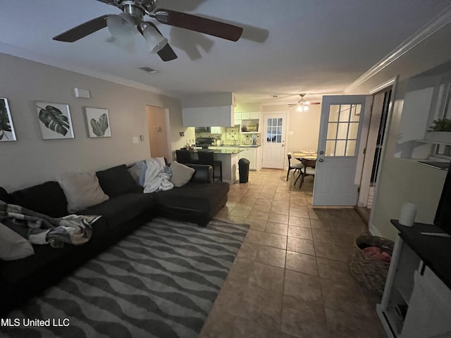 living room with ceiling fan, light tile patterned floors, and crown molding