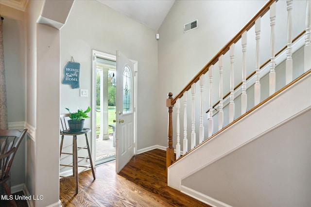 entryway with hardwood / wood-style floors and high vaulted ceiling