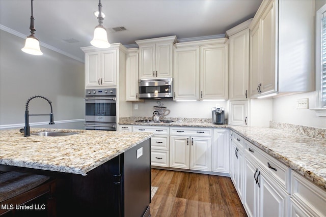 kitchen featuring ornamental molding, appliances with stainless steel finishes, decorative light fixtures, sink, and dark wood-type flooring