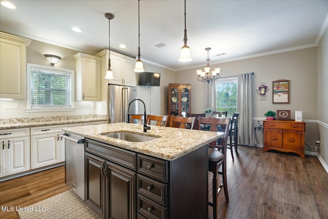 kitchen with a kitchen bar, dark hardwood / wood-style floors, sink, and a kitchen island with sink