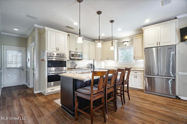 kitchen featuring dark hardwood / wood-style flooring, stainless steel appliances, a center island, and light stone countertops