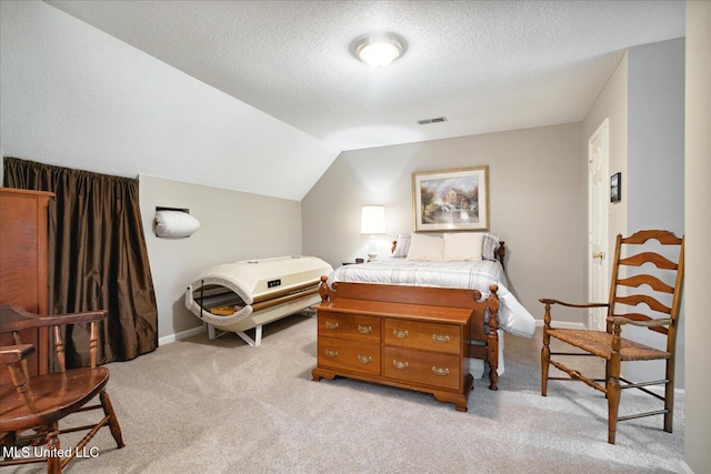 bedroom with light colored carpet, a textured ceiling, and vaulted ceiling