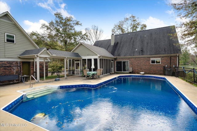 view of pool featuring a patio and a sunroom