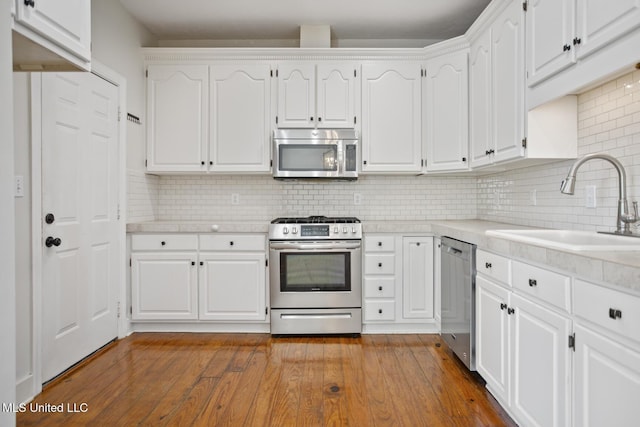 kitchen featuring decorative backsplash, white cabinets, and appliances with stainless steel finishes