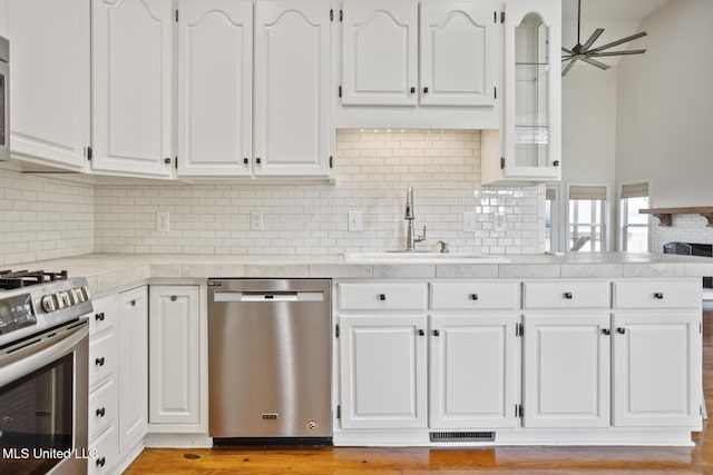 kitchen featuring white cabinets, sink, appliances with stainless steel finishes, and tasteful backsplash