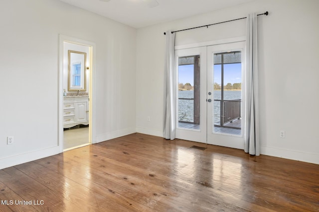 unfurnished room with sink, french doors, and hardwood / wood-style flooring