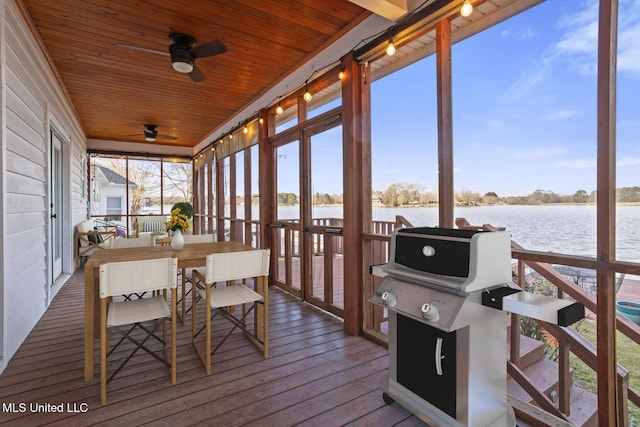 sunroom featuring ceiling fan, a water view, and wooden ceiling