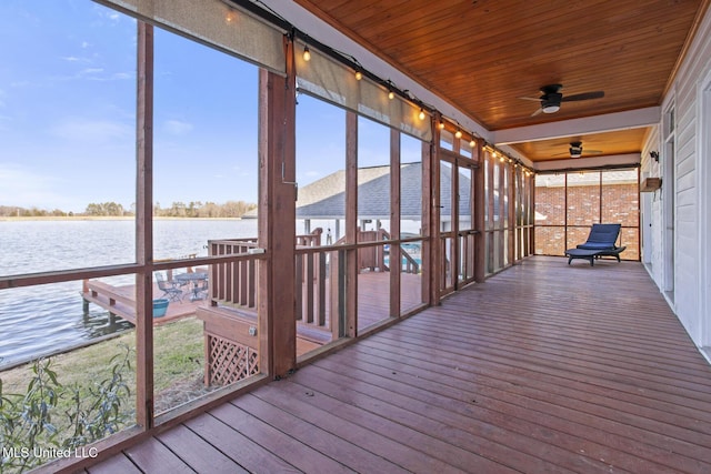 unfurnished sunroom with ceiling fan, a water view, and wood ceiling